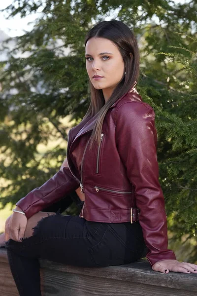 Muhteşem bir esmer model, sonbahar havasının tadını çıkarırken dışarıda poz veriyor.