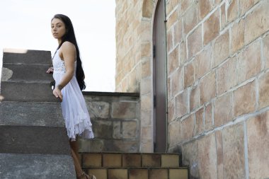 Muhteşem bir esmer model, açık havada bir bahar gününün tadını çıkarıyor. 