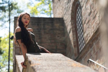 Muhteşem bir esmer model, açık havada bir bahar gününün tadını çıkarıyor. 