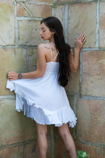 Muhteşem bir esmer model, açık havada bir bahar gününün tadını çıkarıyor. 