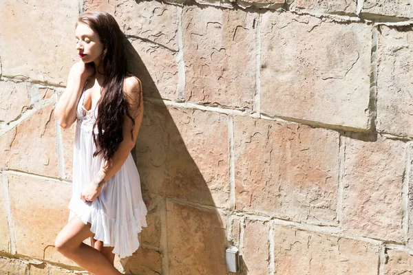 Muhteşem bir esmer model, açık havada bir bahar gününün tadını çıkarıyor. 