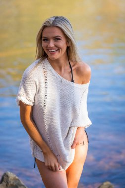 Muhteşem sarışın bir bikini modeli göl kenarında poz verirken yaz havasının tadını çıkarıyor..