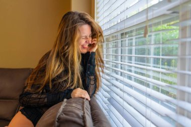 Muhteşem bir esmer model iç çamaşırlarıyla ev ortamında poz veriyor.