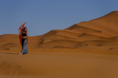 Fas 'taki büyük Sahra Çölü' ndeki kum tepelerine karşı güzel bir model poz veriyor.