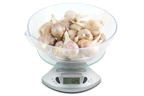 Garlic on the kitchen scales to weigh — Stock Photo, Image