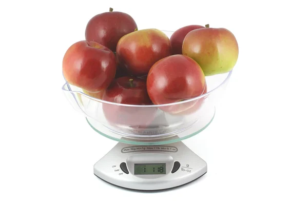 Красные яблоки весом в кухонную шкалу — стоковое фото