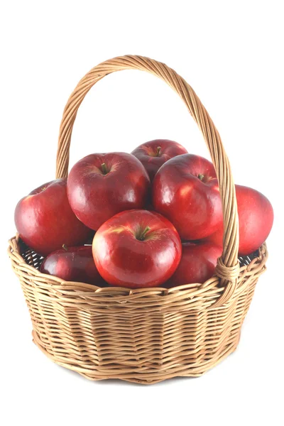 Красные яблоки в плетеной корзине — стоковое фото