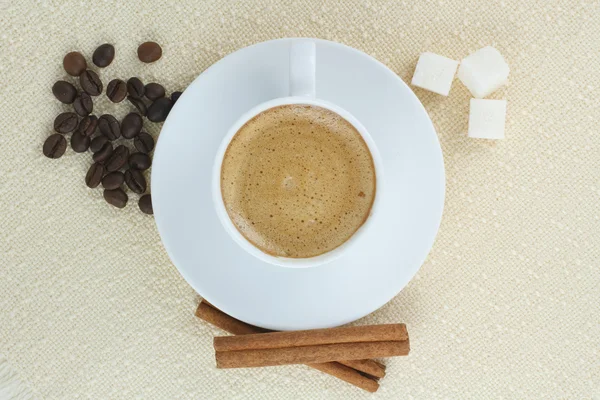 Caffè con panna, zucchero e cannella sulla tovaglia beige . — Foto Stock