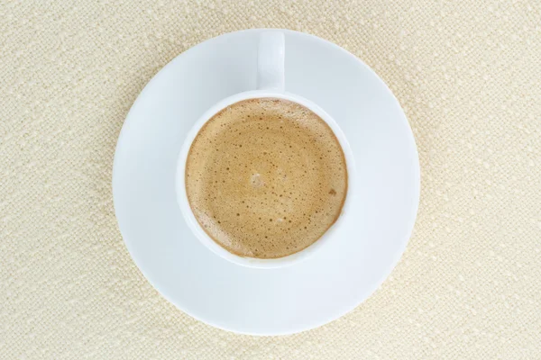 Coffee in a white cup on beige tablecloth — Stock Photo, Image