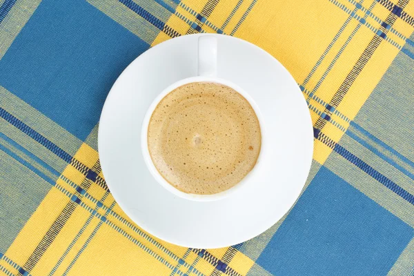 Кофе в фарфоровой тарелке на клетчатой скатерти — стоковое фото