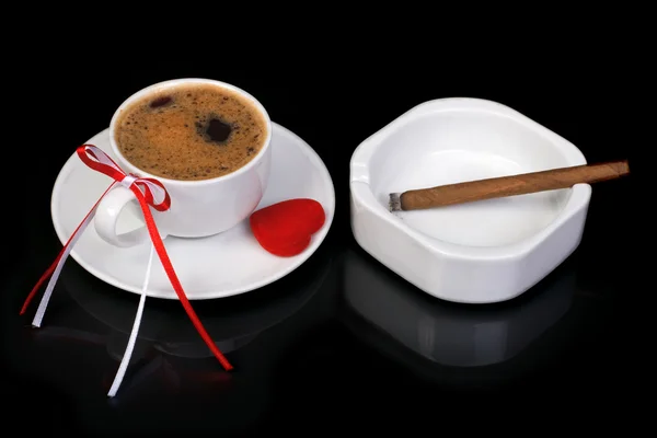 Taza de café decorada con un arco y corazón. Cigarrillo y cenicero — Foto de Stock