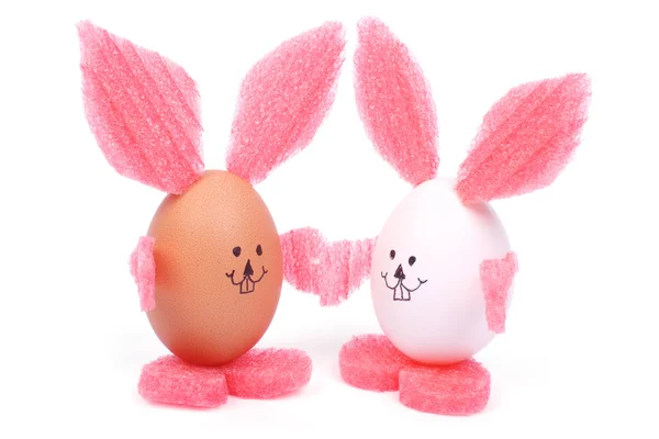 Dvě Velikonoce bunny držení rukou vyrobené vejce, samostatný — Stock fotografie