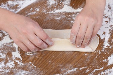 fırıncı hamuru Ahşap mutfak masasının üzerinde döner.