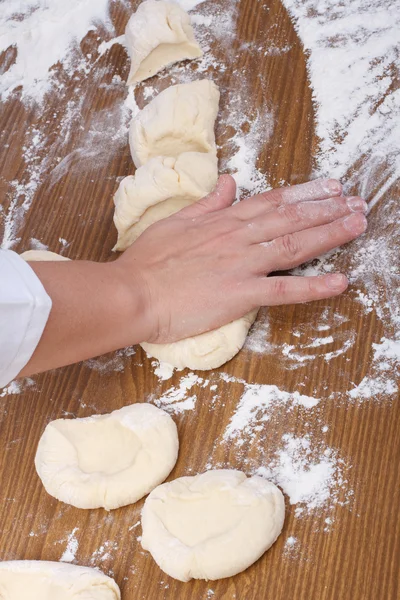 Hand baker makes flat cakes dough. Pressing — Stock Photo, Image