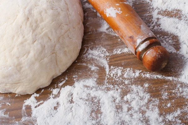 Dough with rolling pin on floured table — Stock Photo, Image