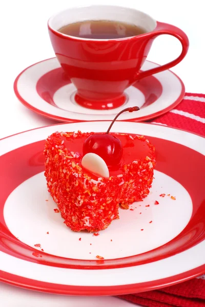 Red in heart shape cake and tea in the background — Stock Photo, Image