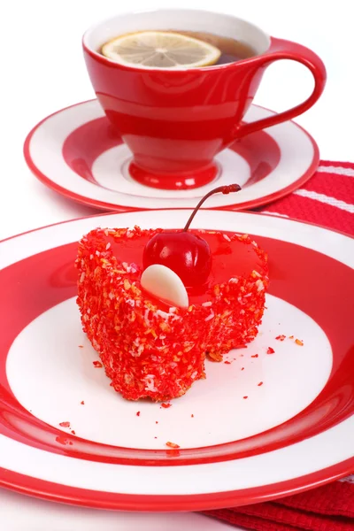 Torta rossa a forma di cuore e tè con limone sullo sfondo — Foto Stock