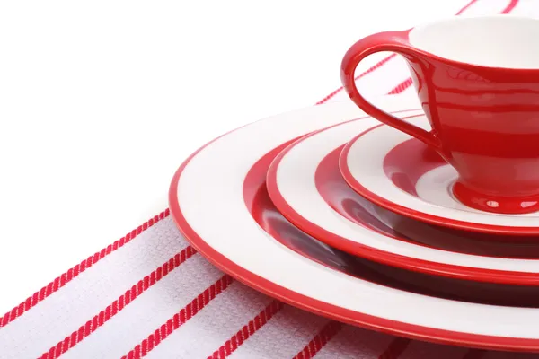Накрываем стол. Красные тарелки и чашки для чая на полосатой салфетке — стоковое фото