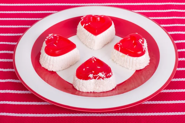 Gâteaux en forme de cœur avec noix de coco sur une assiette rouge — Photo