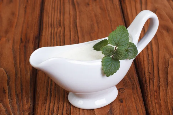 White bechamel with mint leaves on a wooden surface — Stock Photo, Image