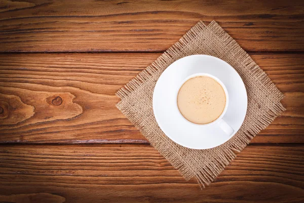 Coffee with milk on a napkin from a sacking top view — Stock Photo, Image