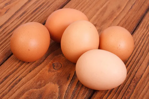 Five brown chicken eggs on an oak wood table — Stock Photo, Image