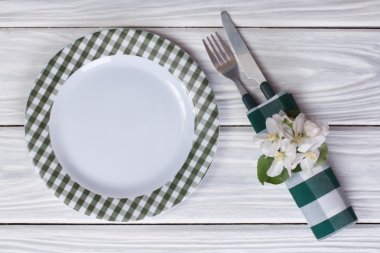 tabak ve çatal bıçak takımı ahşap bir masa üzerinde Apple çiçeklerle süslenmiş. Üstten Görünüm.