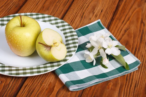 Green apple on a white plate on a napkin — Stock Photo, Image