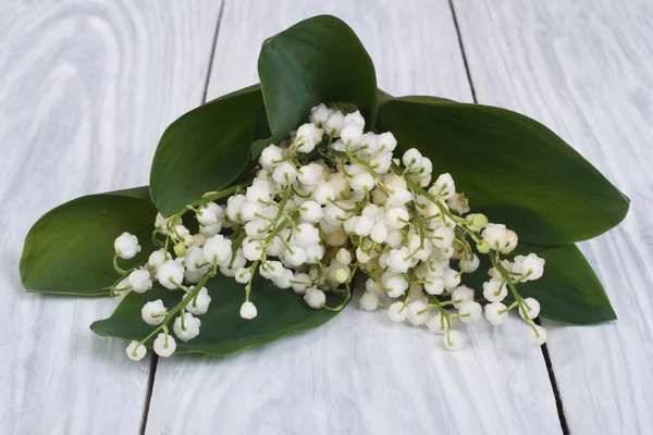 Bouquet di gigli della valle sulla tavola di legno grigia — Foto Stock