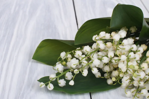 Lilies of the valley on the gray wooden plank close-up — Stock Photo, Image