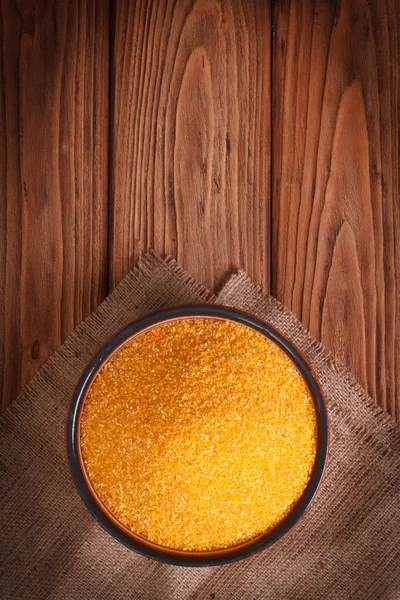 Corn groats in a bowl on a wooden table. top view — Stock Photo, Image