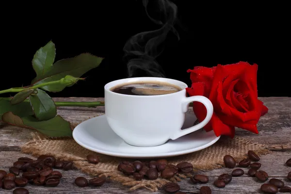 Hot black coffee and red rose on a wooden table. low key — Stock Photo, Image