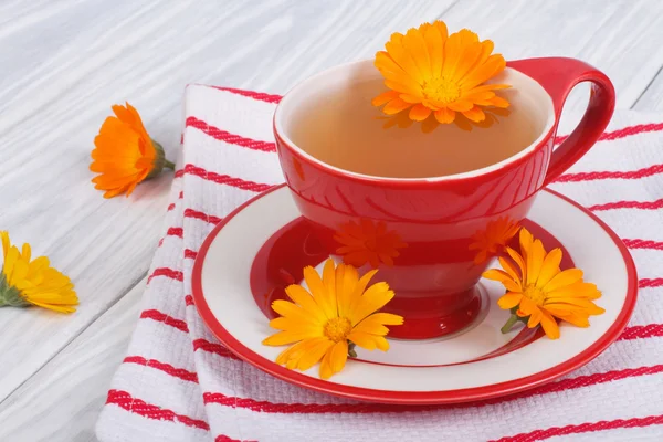 Calendula flower tea on striped tablecloth on the table — Stock Photo, Image