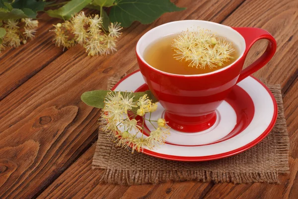 Kruiden thee met linden bloemen op een bruine houten tafel — Stockfoto