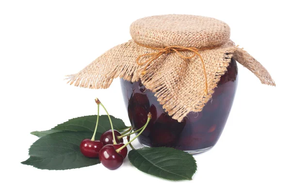 Cherry jam in een glazen pot en rijpe verse bessen geïsoleerd — Stockfoto