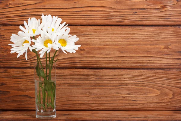 Beautiful bouquet of chamomile flowers in a glass vase — Stock Photo, Image