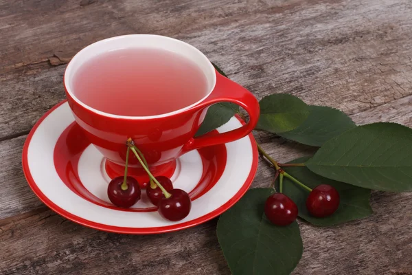 Fruit thee met cherry bessen op oude houten tafel — Stockfoto