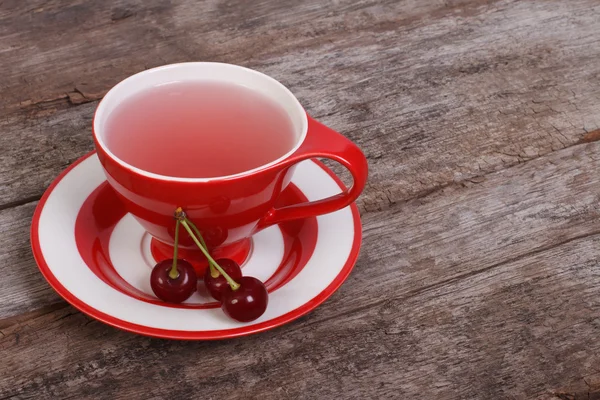 Té de frutas con bayas de cereza sobre tabla de madera vieja —  Fotos de Stock