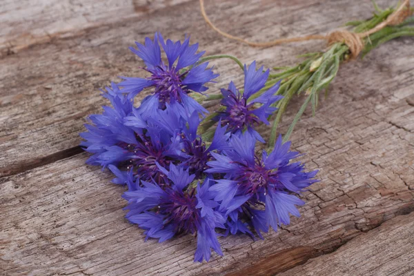 Korenbloem blauwe wilde bloemen op een oude houten bord — Stockfoto