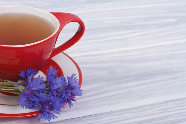 Tè con petali di fiordaliso selvatico sul tavolo. primo piano — Foto Stock