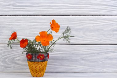 güzel bir vazoda turuncu eshsholtsiya çiçekler buket