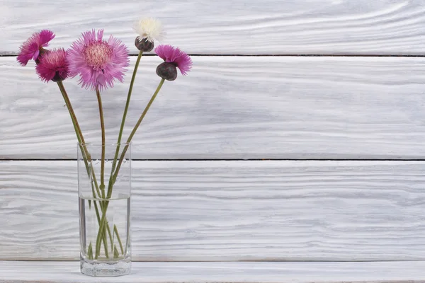 Букет з різнокольорових квітів у скляній вазі — стокове фото