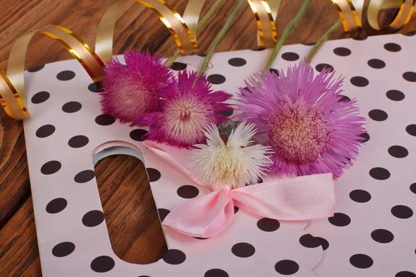 Pink gift bag with bow and cornflowers — Stock Photo, Image