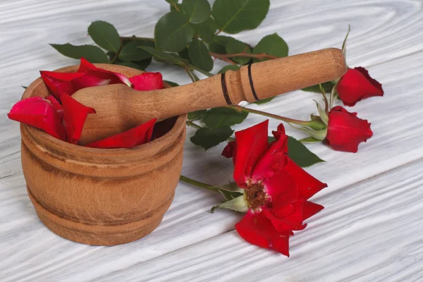 Mortel met rozenblaadjes en een rode bloemknoppen — Stockfoto