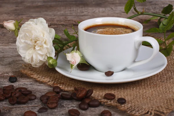 Caffè nero sul tavolo e un fiore di rosa bianca — Foto Stock