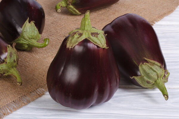 Ripe round aubergines on a wooden table