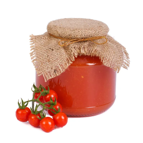 Tomatensaus in een glazen pot en verse tomaten geïsoleerd — Stockfoto