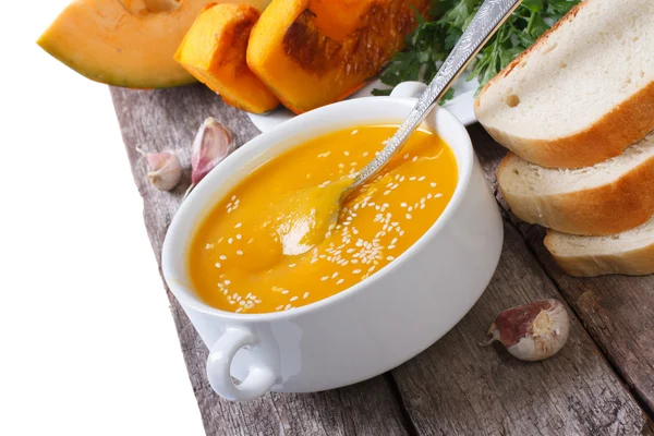 Pumpkin soup with sesame seeds and bread on a wooden table — Stock Photo, Image