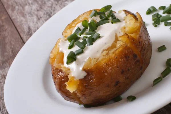 Gebakken aardappel met zure room en groene uien — Stockfoto