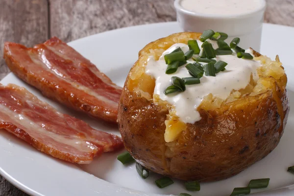 Patatas al horno con salsa y tocino frito — Foto de Stock